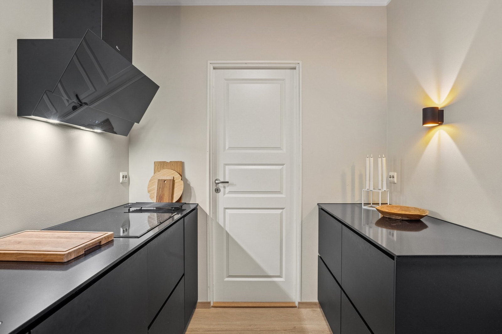 Moderne kjøkken med integrerte hvitevarer. Døren går inn til praktisk vaskerom Galleribilde