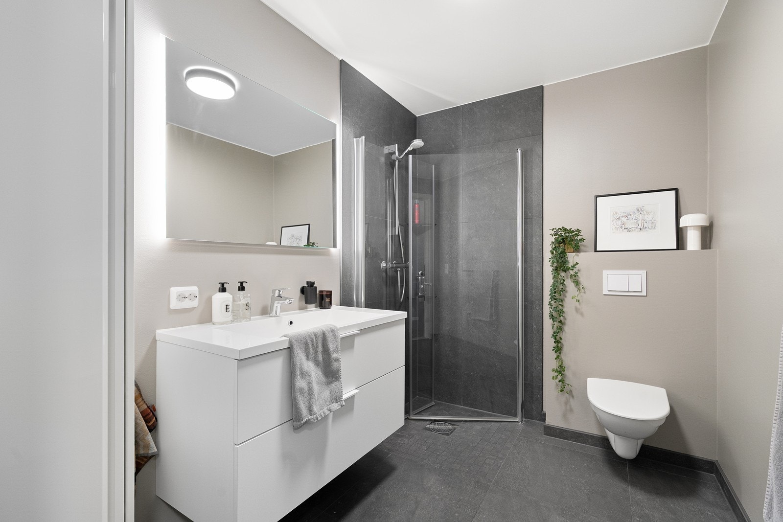 Malt glassfiberstrie på veggene og fliser i dusjområdet. Gulvet er flislagt og utstyrt med elektriske varmekabler som gir ekstra komfort. Galleribilde