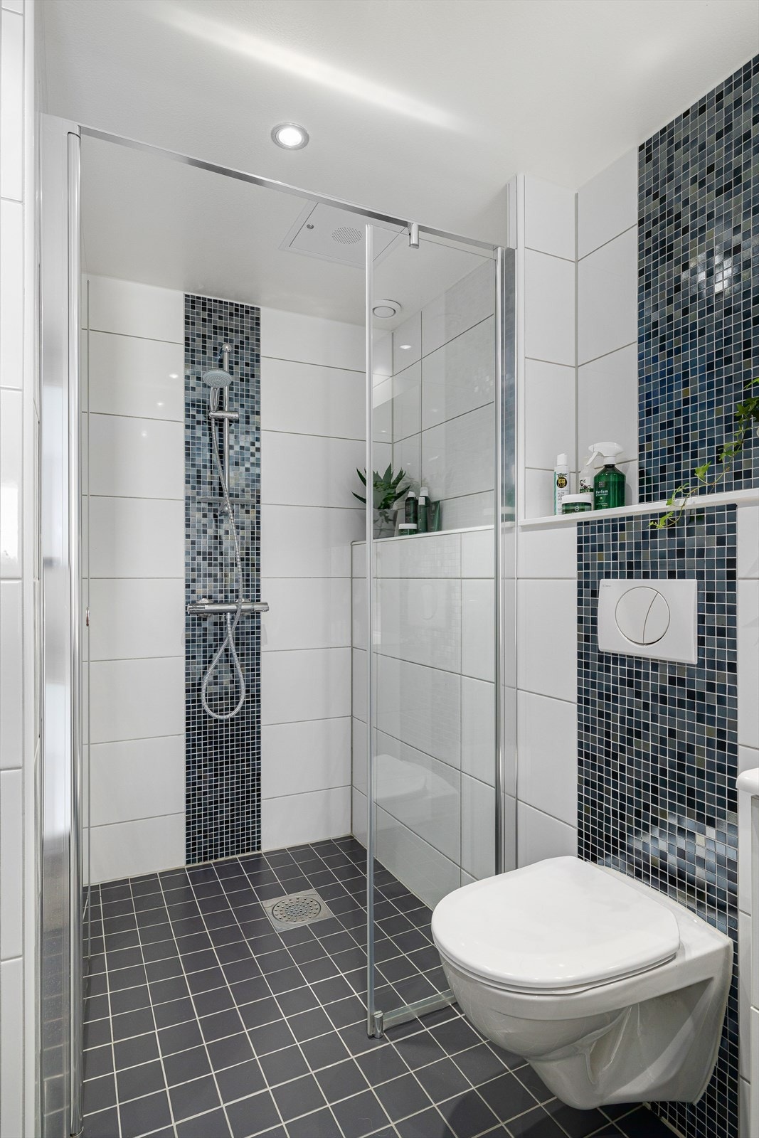 Delikate fliser på både gulv og vegger gir baderommet et moderne og innbydende uttrykk, samtidig som det er lett å holde rent. Galleribilde