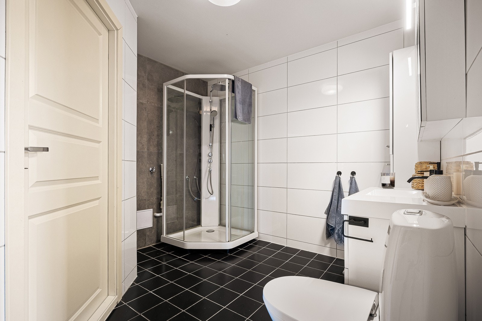 - Videre er badet innredet med toalett, baderomsinnredning med speilskap, matchende sideskap, dusjkabinett og opplegg for vaskemaskin - Galleribilde