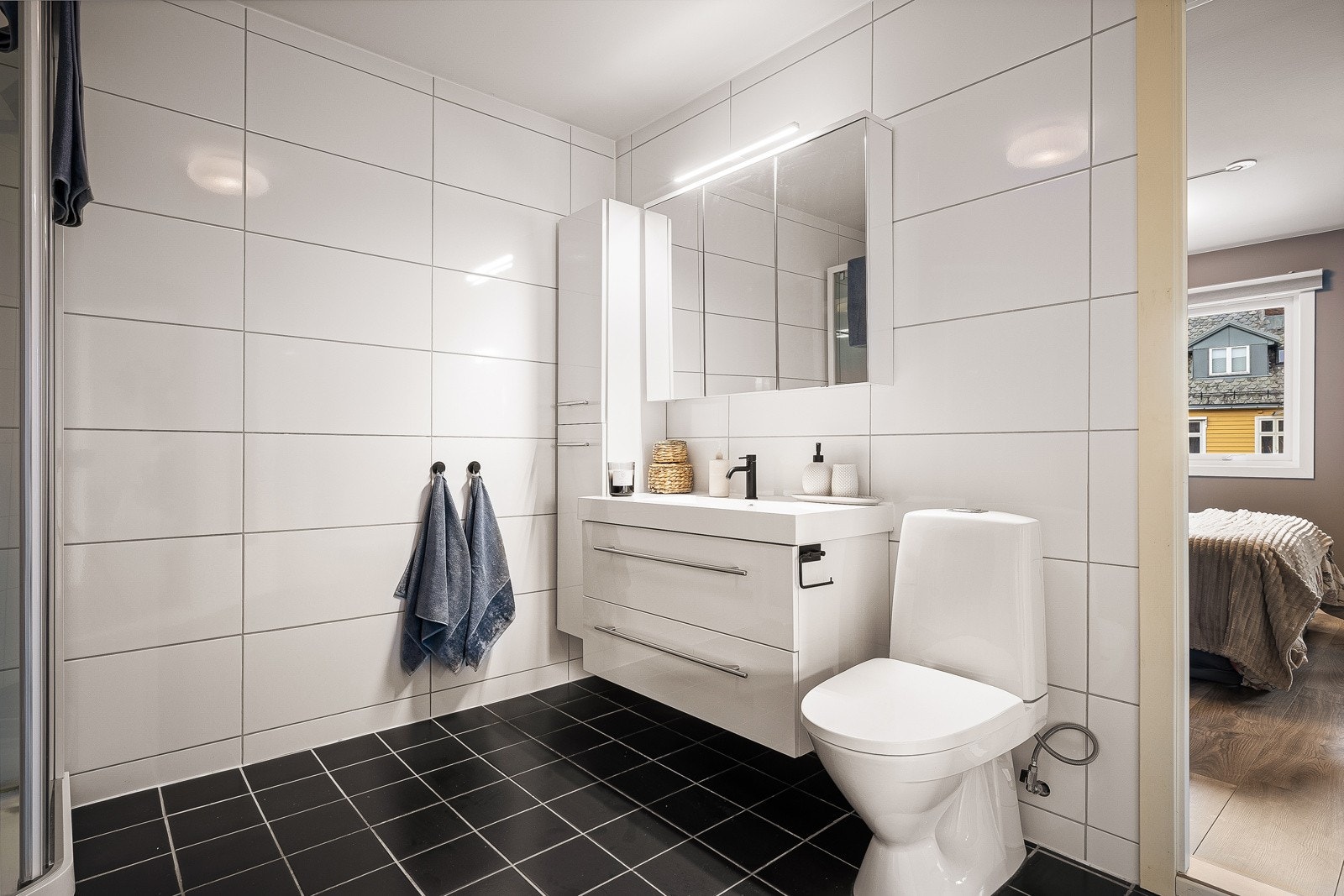 - Badet har en klassisk utførelse med lyse fliser på vegger og mørke fliser på gulv - Galleribilde