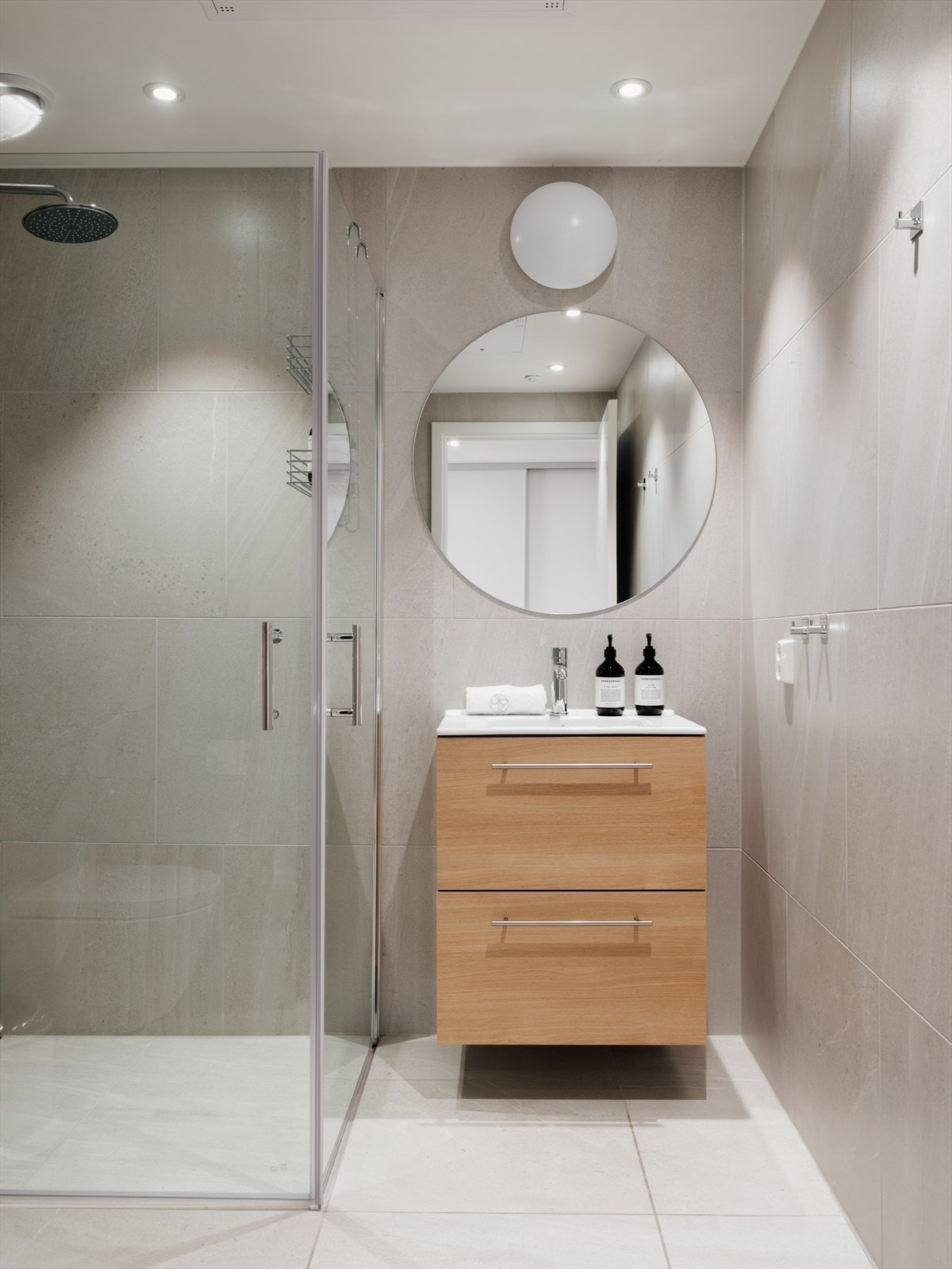 Bad 2 inn fra entré. Med toalett, regnfalldusj og innsvingbare dusjdører i glass, servant med skuffer og downlights i himling. Varmekabler i gulv. Galleribilde