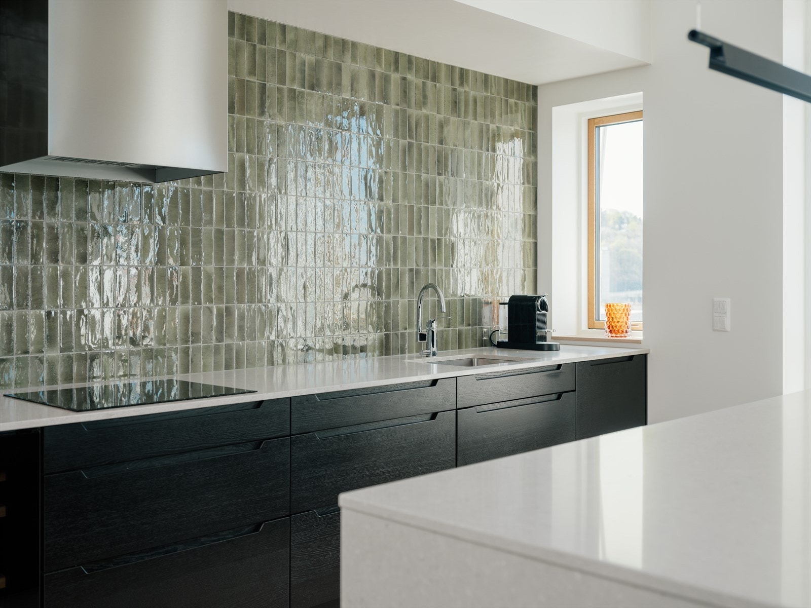 Pene, slette fronter, polert kompositt benkeplater og sidevanger på arbeidsøy. Fliser på vegg og kjøkkenøy. Integrerte elektriske stekeovn, platetopp, oppvaskmaskin, kjøleskap og fryser. Galleribilde