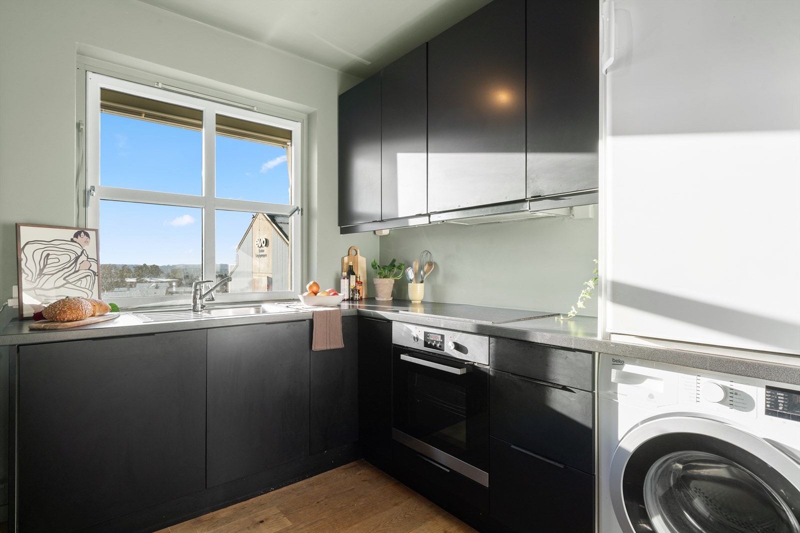 Kjøkkenet har et klassisk og pent design med sorte, slette fronter fra 2021. Galleribilde