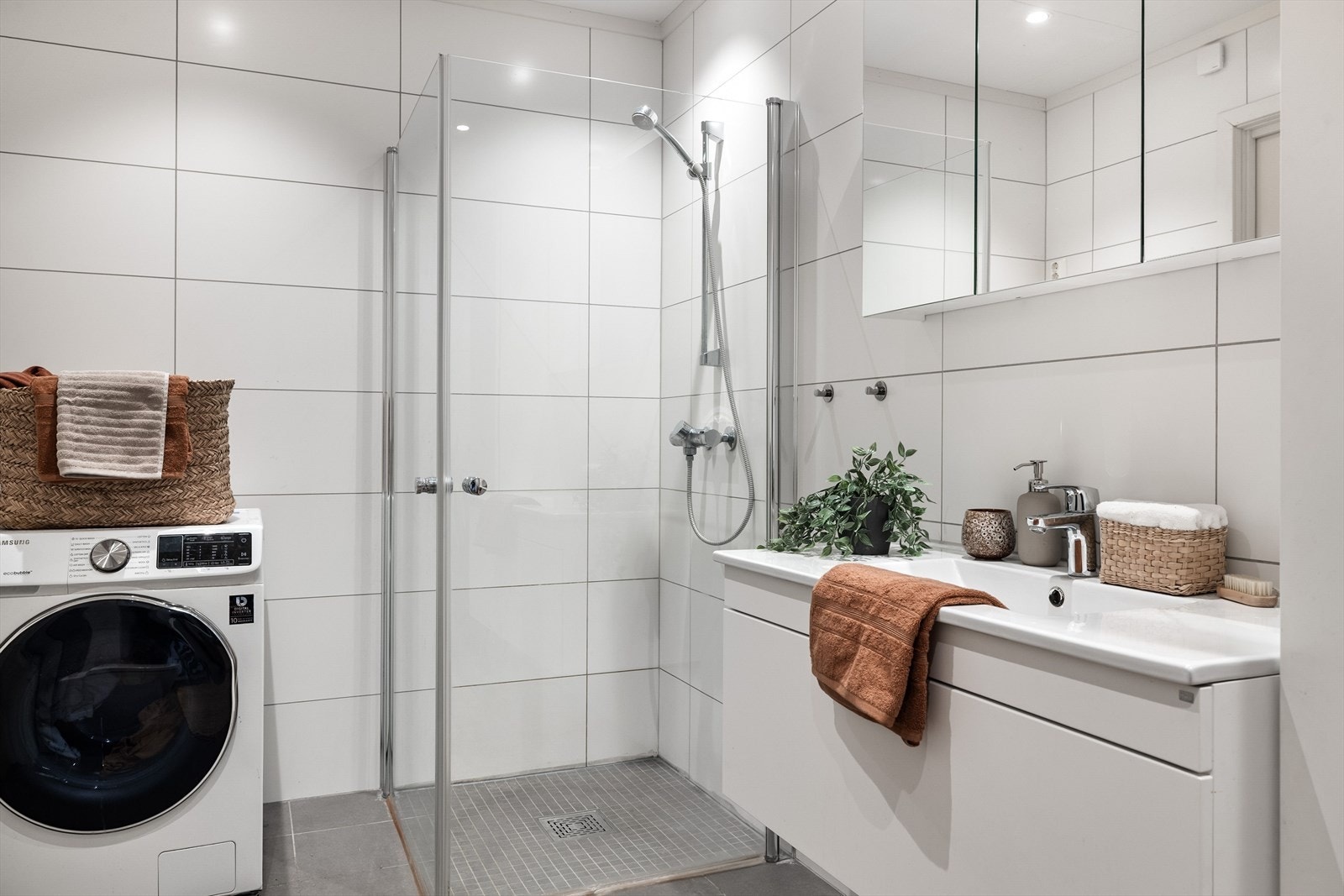 Dusjhjørne med innfellbare glassdører. I hjørnet er det plass og opplegg for vaskemaskin, samt tørketrommel over om ønskelig. Galleribilde
