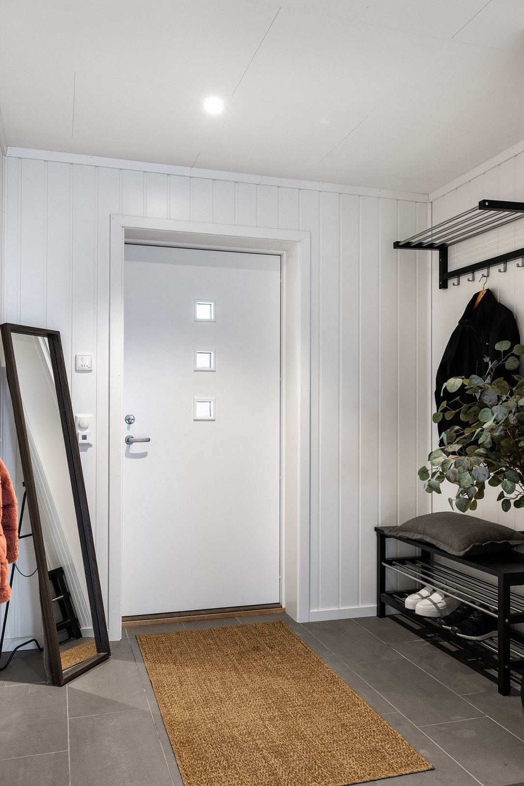 Når du entrer boligen, kommer du inn i en lys og praktisk entré med plass til sko og oppheng av yttertøy. God standard fra 2020 med flislagt gulv med gulvvarme, lyse panelplater på veggene, skjult elektrisk anlegg og downlights i himlingen. Galleribilde