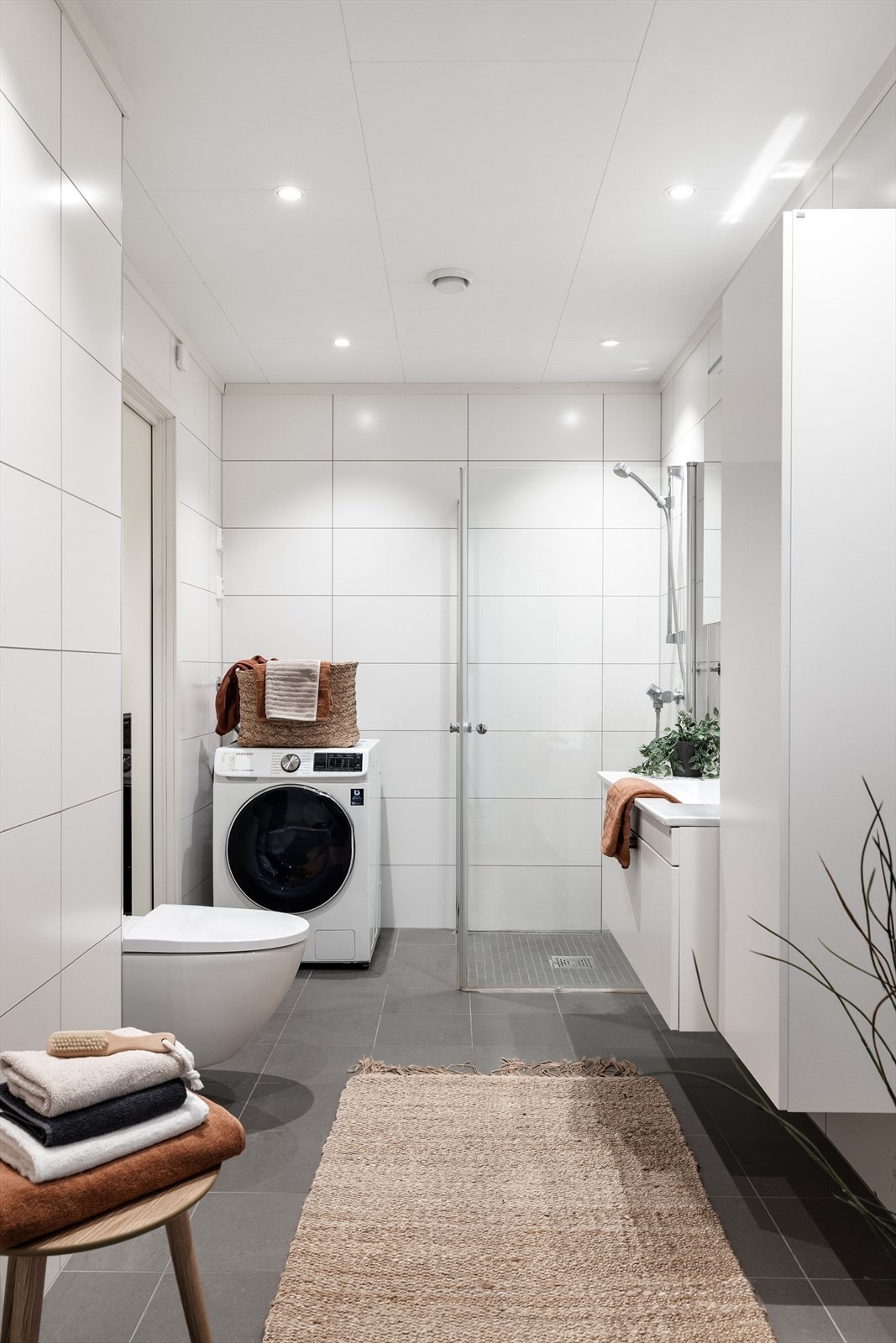 Boligen har et lyst og moderne baderom fra byggeåret 2020. Baderommet har grå fliser på gulv, deilig gulvvarme, hvite fliser på veggene, downlights i himlingen og avtrekk via balansert ventilasjon. Galleribilde