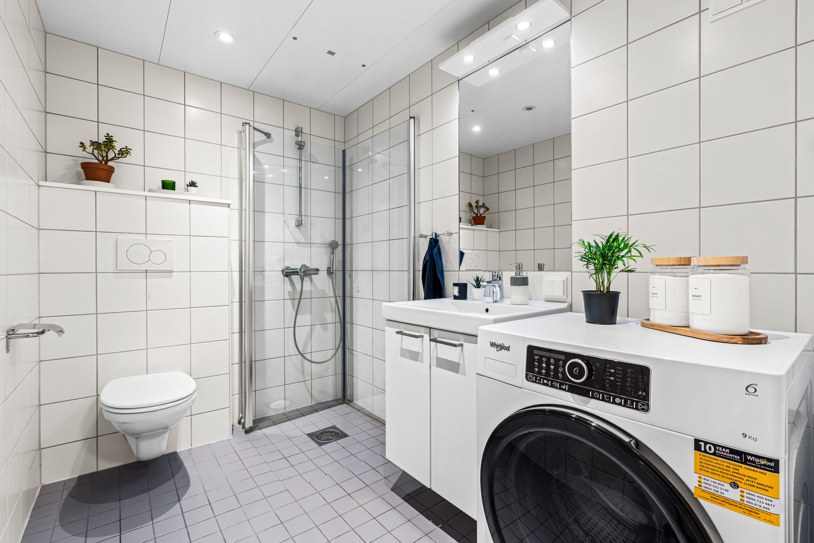 Lyst og fint flislagt bad med god plass til vaskemaskin. Galleribilde