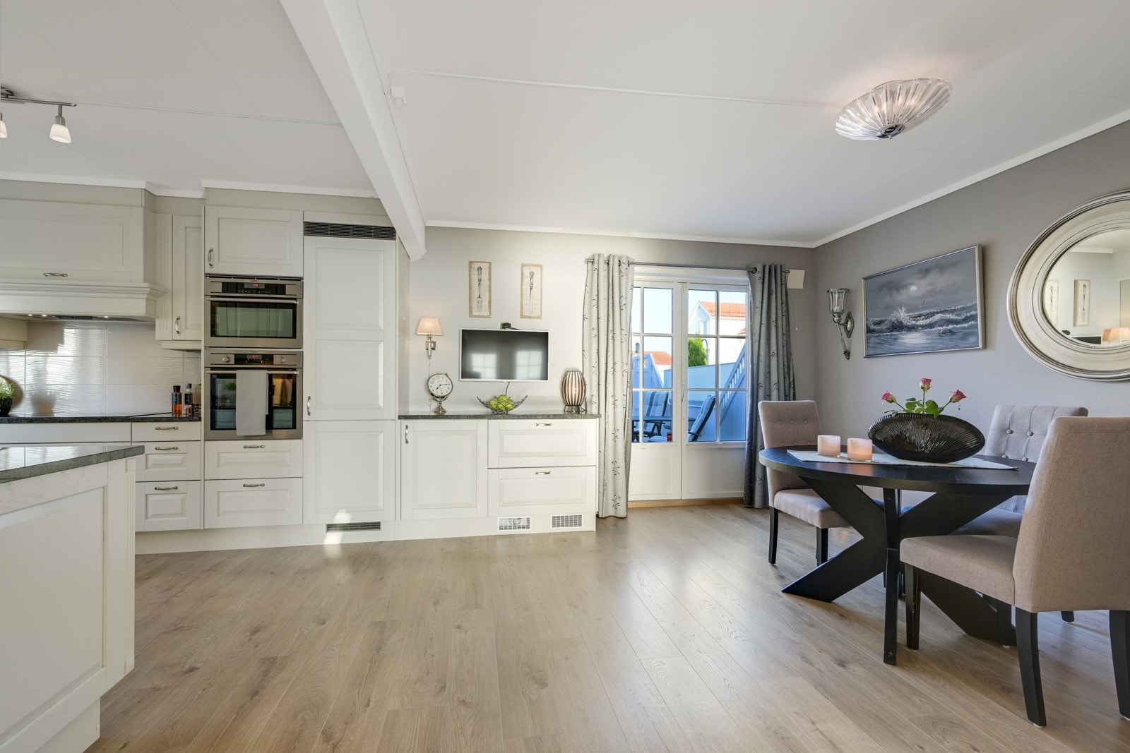 Fra kjøkkenet er det tofløyet dør ut til en romslig terrasse Galleribilde