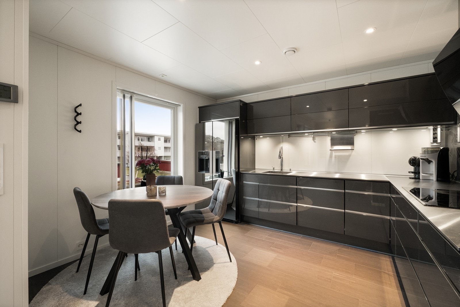 Kjøkkenet er innredet i tidsriktig stil med glatte, mørke fronter og benkeplate i børstet stål. Galleribilde