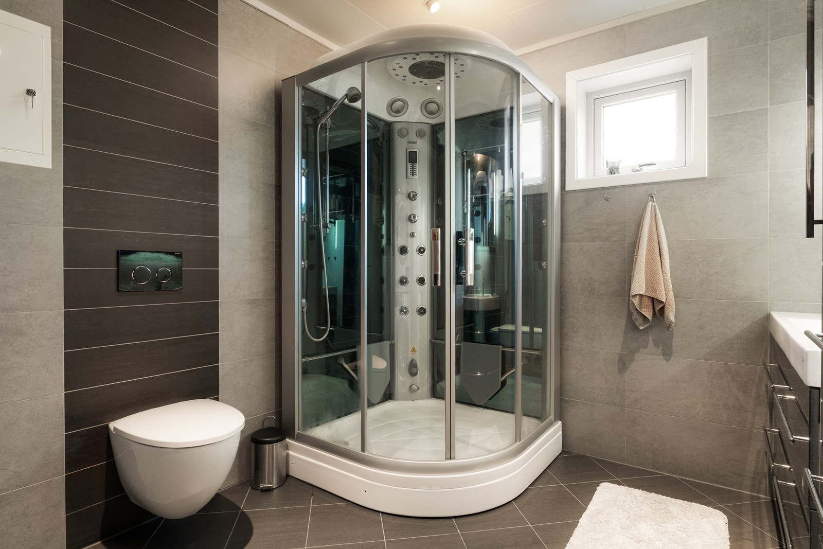 Videre er det vegghengt toalett og dusjkabinett med trope- og steamfunksjon. Galleribilde