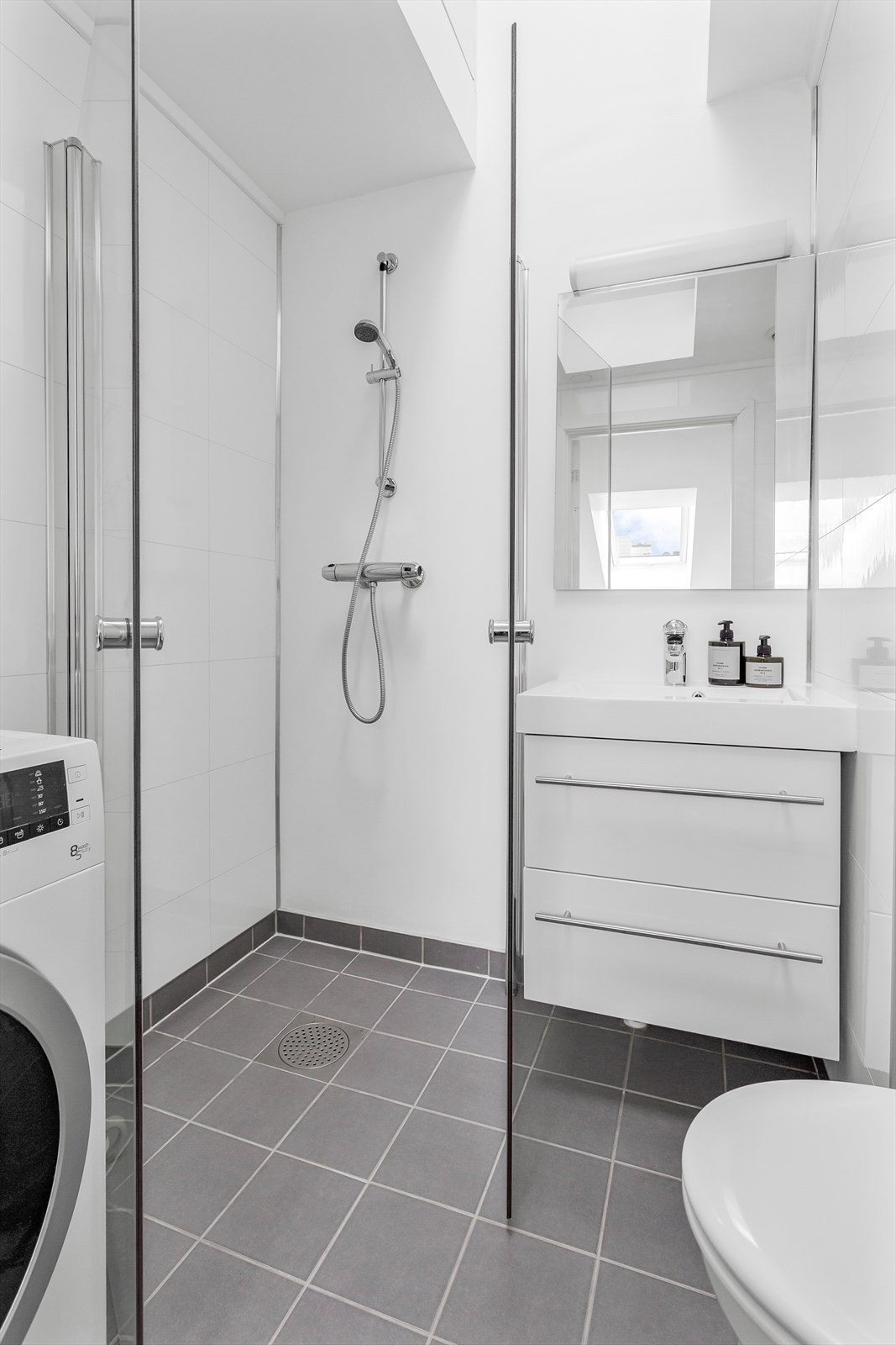 Innredningen består av en moderne servant med skuffer, vegghengt toalett og dusjhjørne. Galleribilde