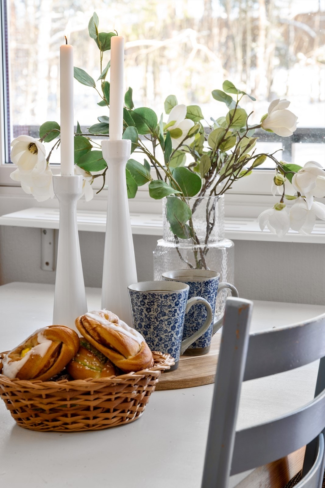 God helg: Et stemningsfullt øyeblikk fra kjøkkenets romslige spiseplass - med tente lys på bordet og duften av fersk gjærbakst i kurven. Galleribilde