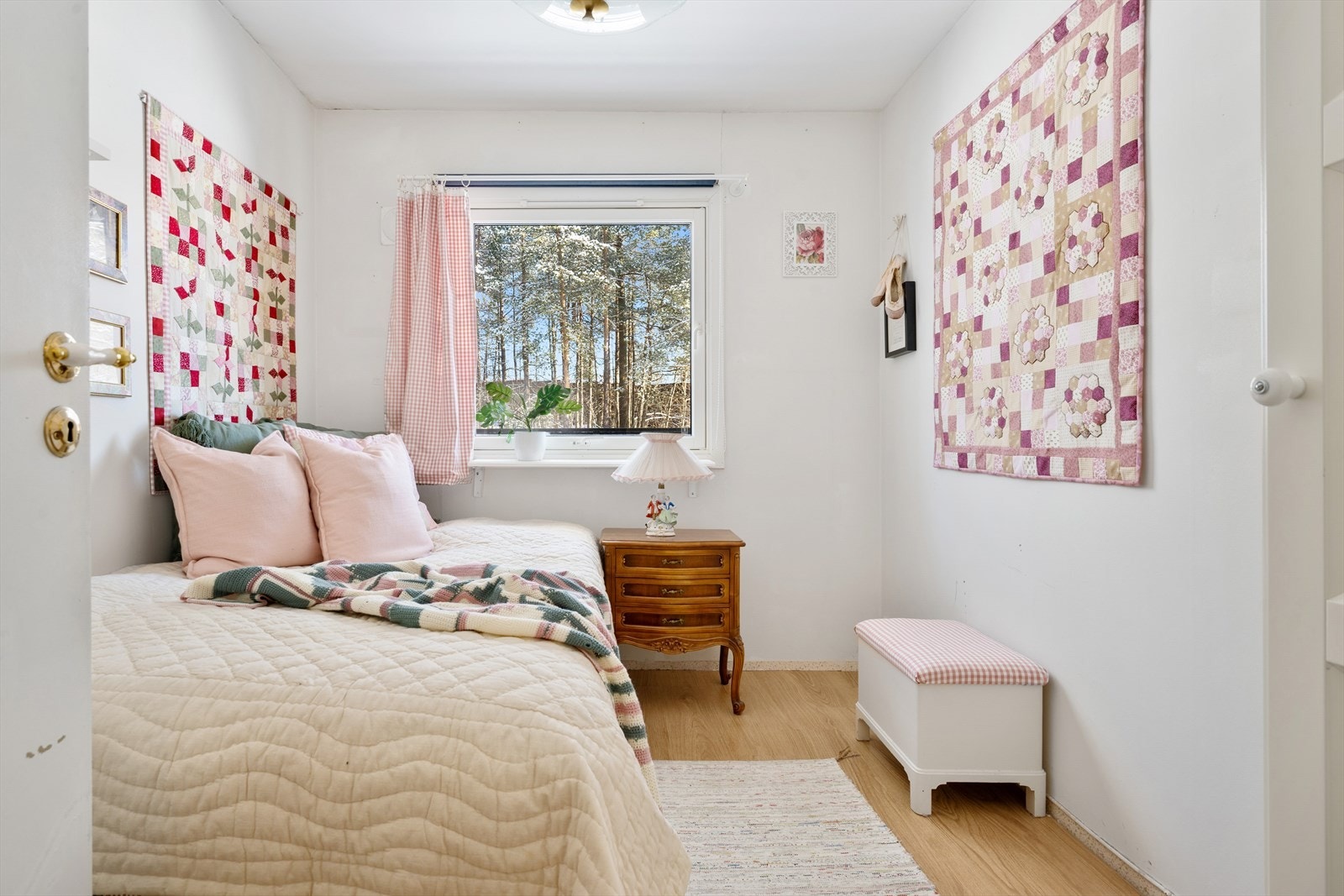 Tilbaketrukket: Soverom nr. 2 er et lyst og sjarmerende rom med lysmalte vegger som gir en luftig og behagelig atmosfære. Veggen prydes av kreative lappetepper, som tilfører personlig preg, farger og varme, og gjør rommet unikt og innbydende. Galleribilde