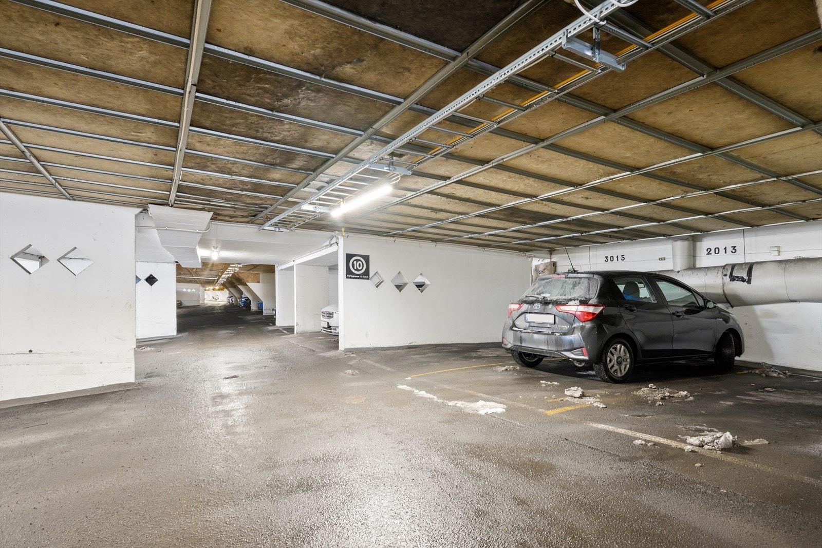 Rett under leiligheten: Til leiligheten følger en praktisk garasjeplass i felles garasjeanlegg under terrasseblokkene, som gir enkel og trygg parkering uansett vær. Galleribilde