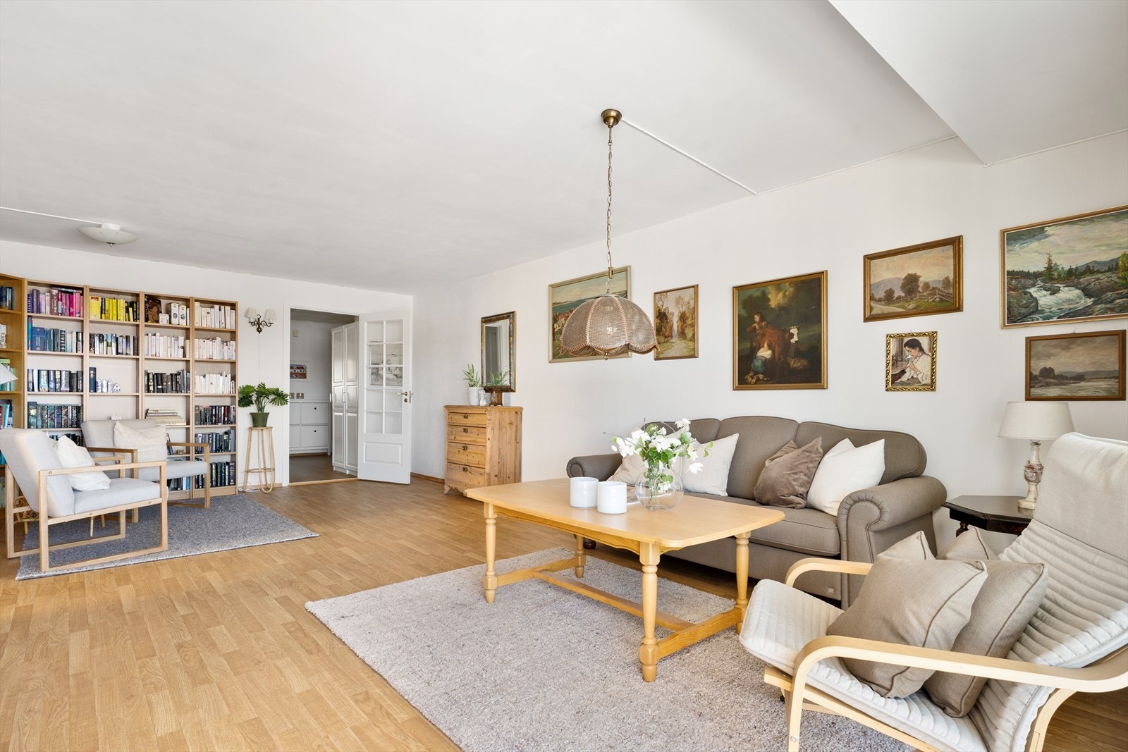 Slå deg løs: Stuen i leiligheten er både romslig og fleksibel, og legger til rette for en rekke møbleringsmuligheter. Med store vindusflater og skyvedør ut til balkongen, slipper dagslyset inn fra flere sider, noe som gir en lys og luftig atmosfære. Galleribilde