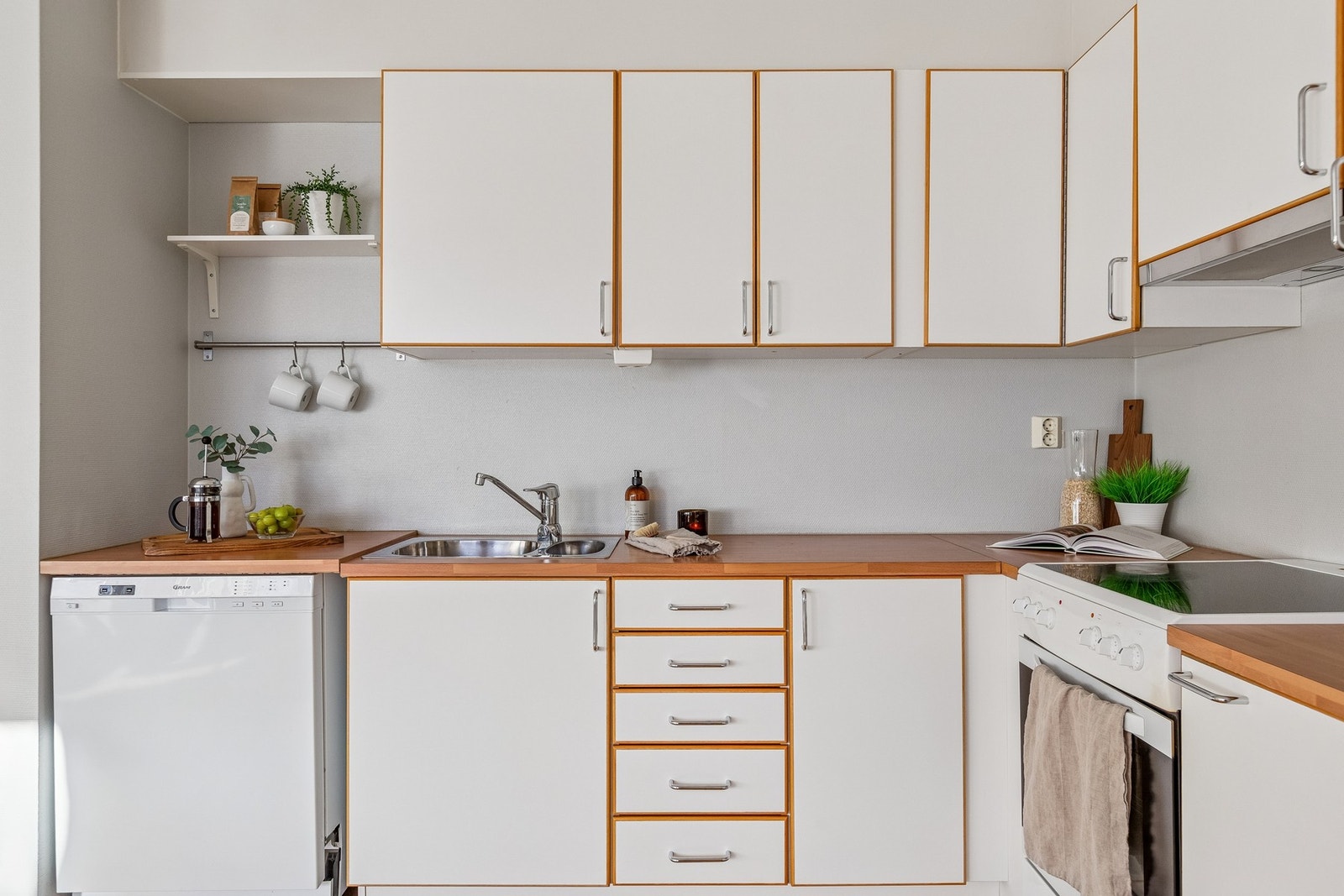 Kjøkkeninnredning med plane fronter og laminerte benkeplater. Galleribilde