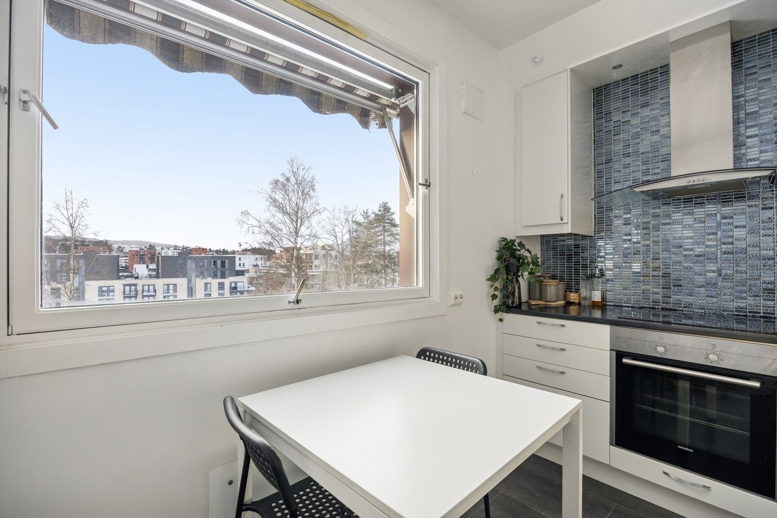 Videre er kjøkkenet innredet med integrert platetopp, komfyr, mikro, oppvaskmaskin og kjøl/frys. Galleribilde