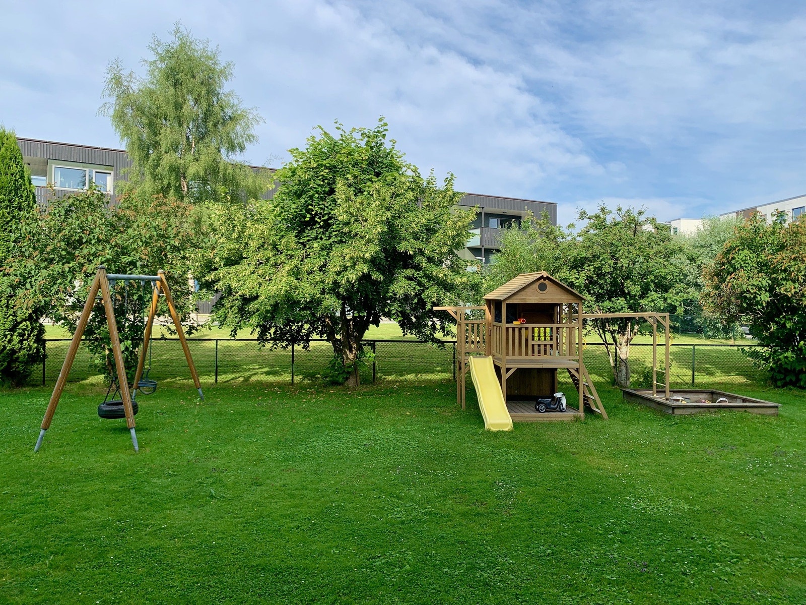 Fra altanen er det en egen utgang til inngjerdet hage med lekestativ og felles grill- og sitteplass. Galleribilde