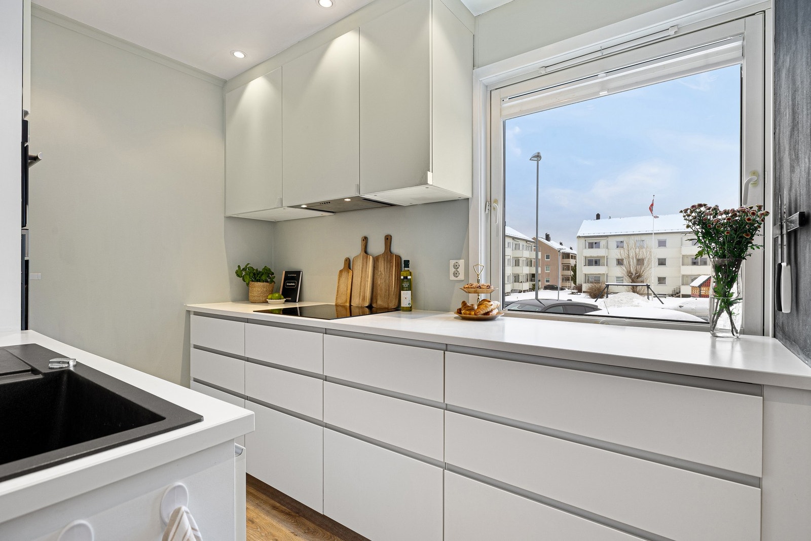 Godt belyste arbeidsflater og fint utsyn ved benken. Det ble satt inn en ny stekeovn i 2023, og oppvaskmaskinen er ny fra 2025. Galleribilde