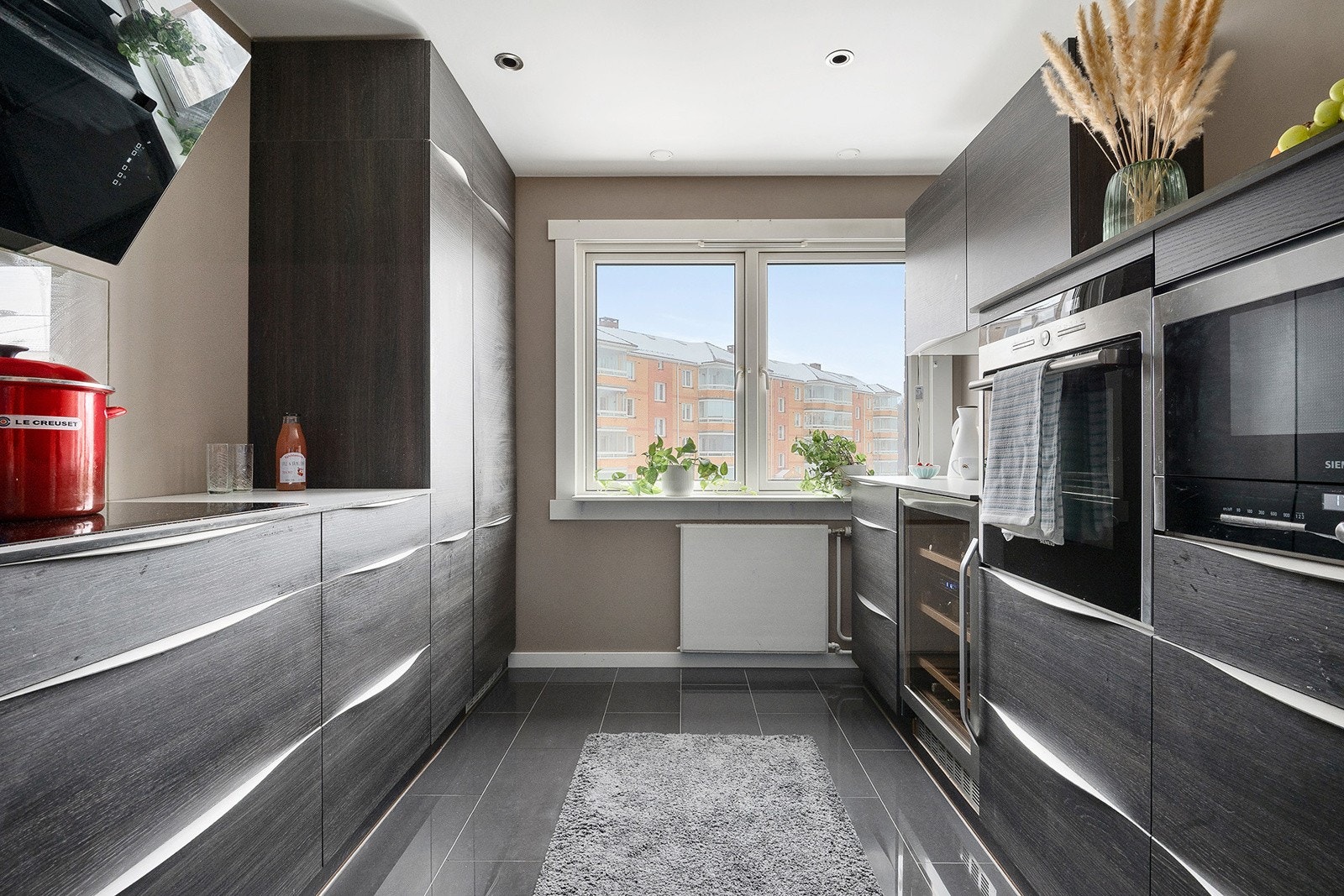 Pen og moderne kjøkkeninnredning fra Kvik med god skap- og benkeplass. Galleribilde