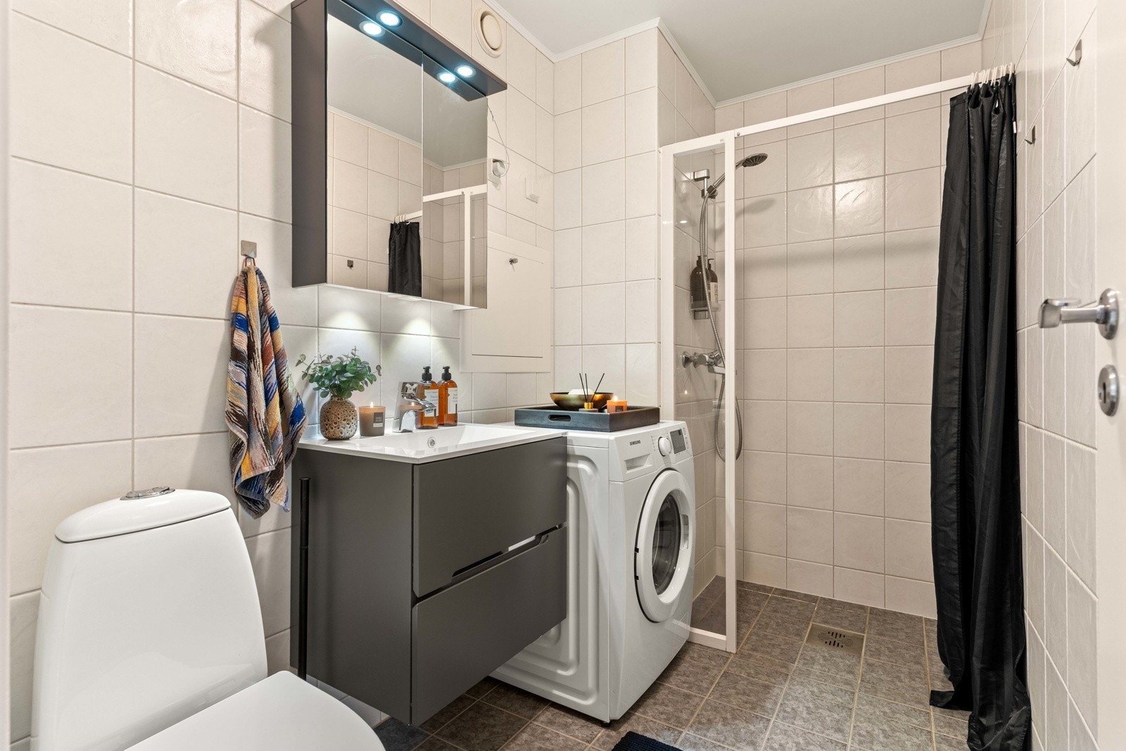 Badet er fra byggeår og er flislagt med dusjløsning, servant og toalett. Det er opplegg for vaskemaskin. Galleribilde