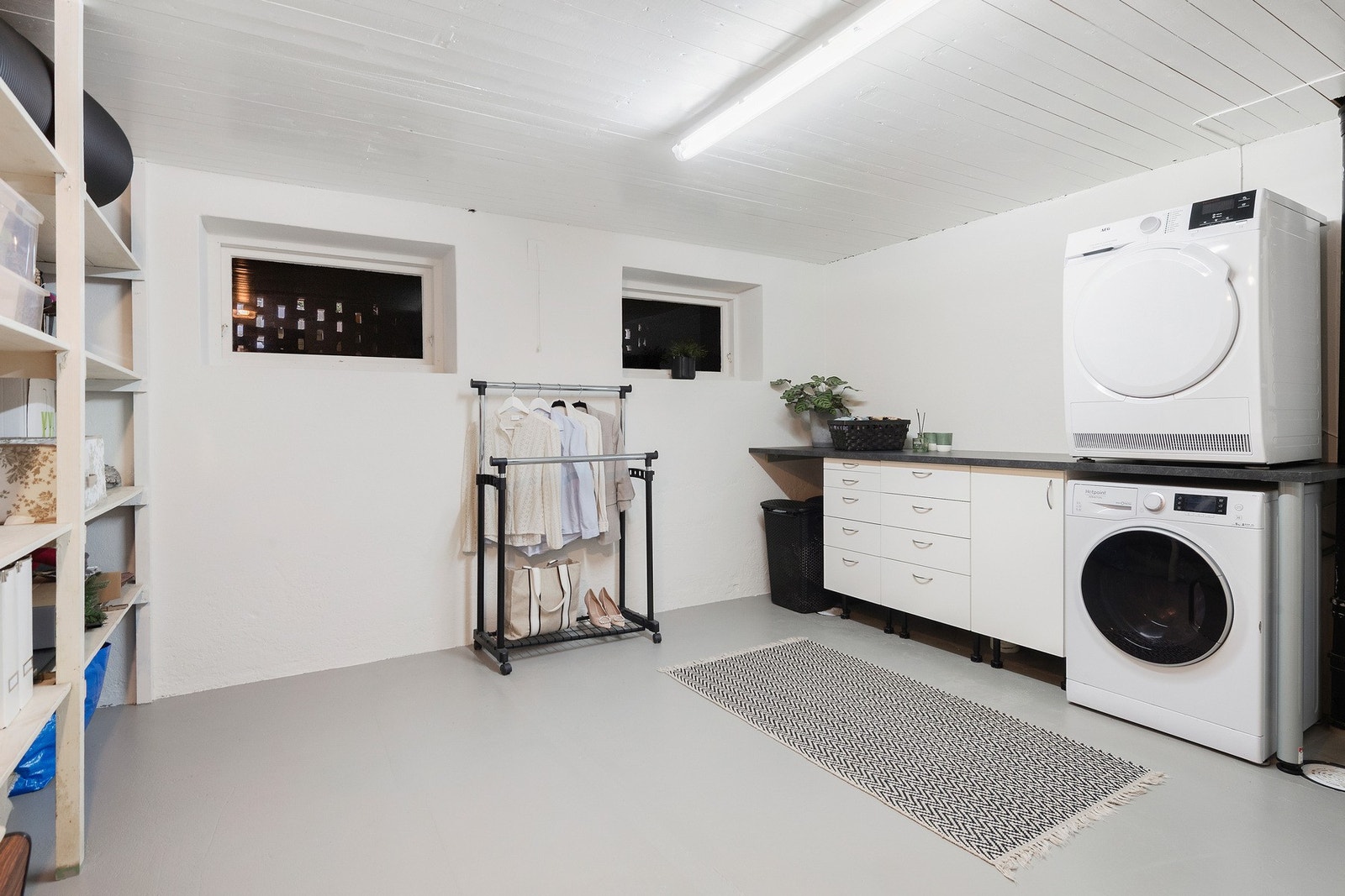 Lyst og romslig vaskerom med praktisk opplegg til vaskemaskin og tørketrommel, samt gode oppbevaringsmuligheter. Galleribilde