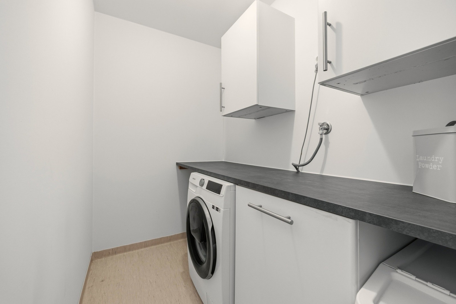 Praktisk vaskerom med arbeidsbenk og skapplass Galleribilde