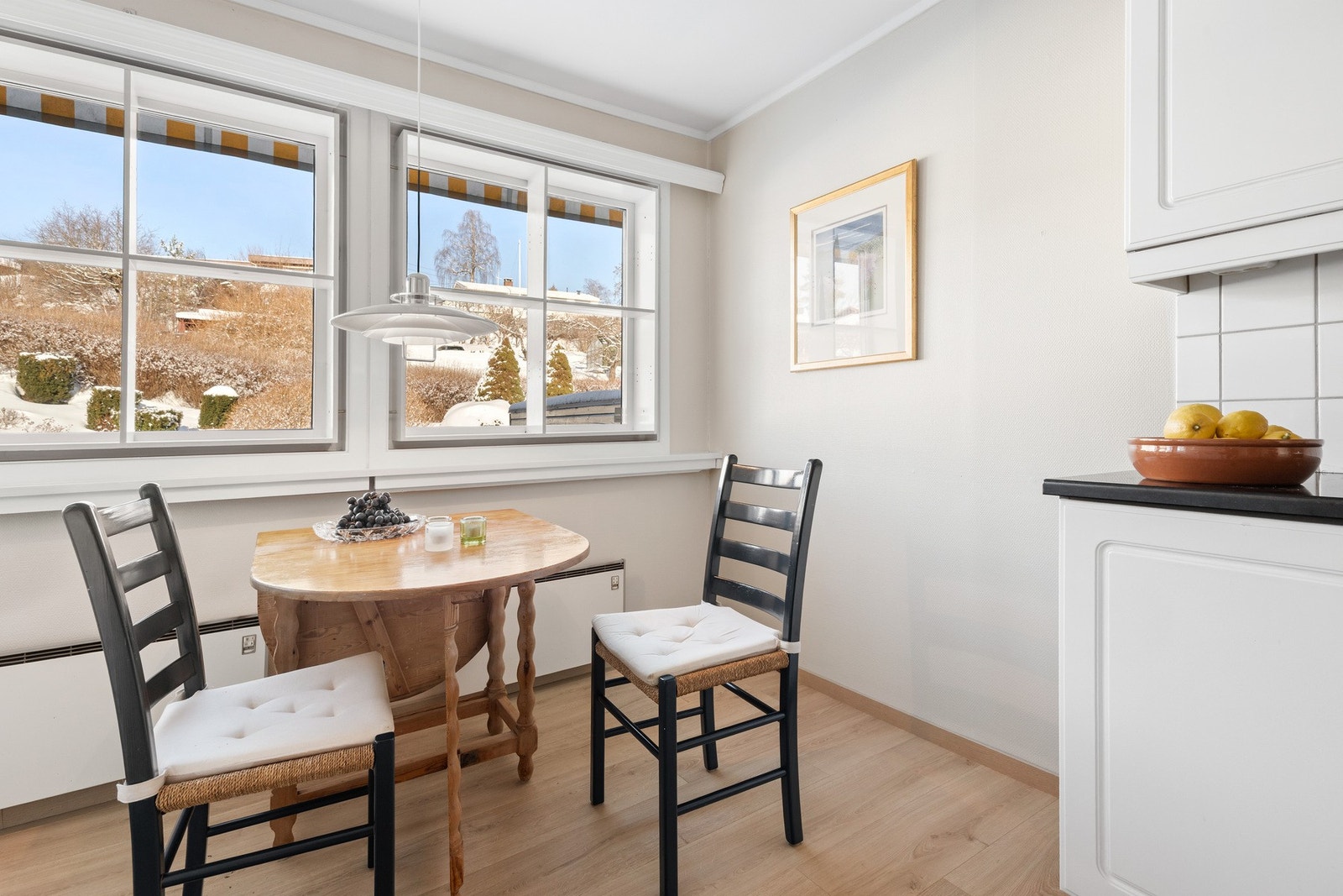 Plass til frokostbord i kjøkkenet ved vinduene mot baksiden av huset med utsyn ut over sameiets fine fellesområder Galleribilde