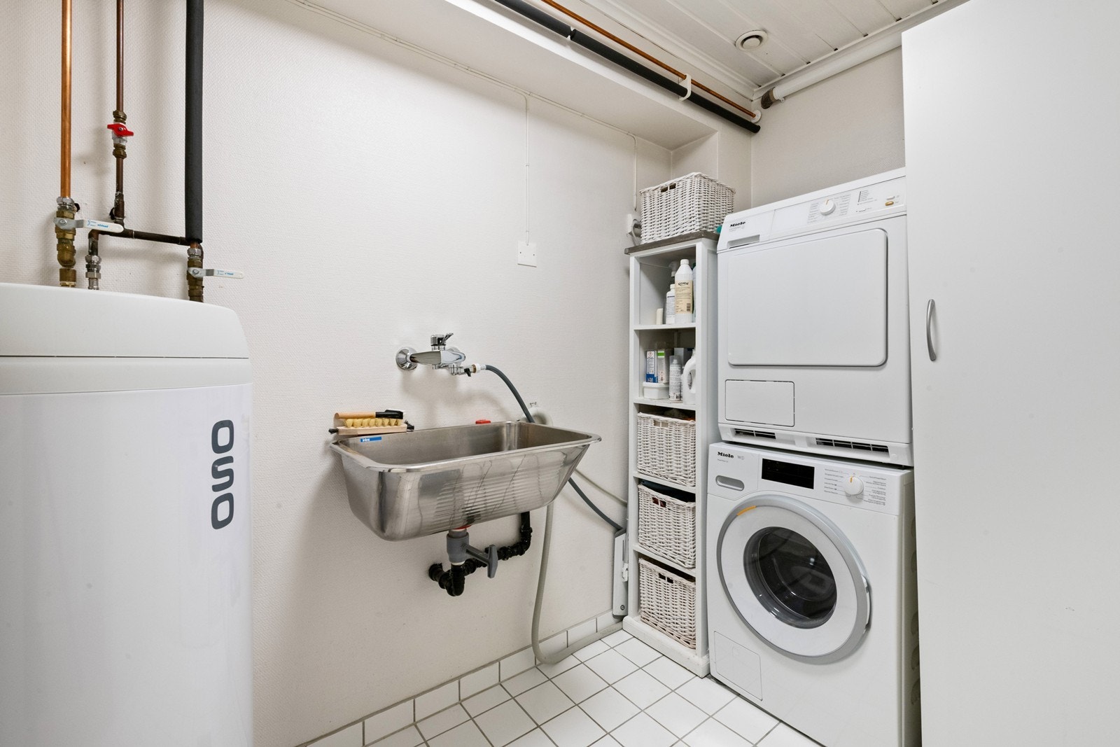 Praktisk vaskerom med opplegg for både vaskemaskin og tørketrommel Galleribilde