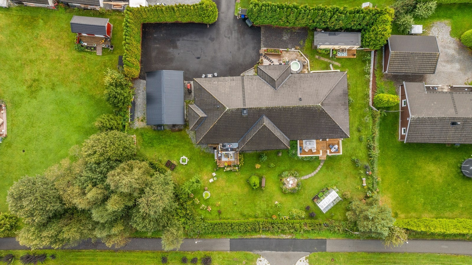 Oversiktsbilde. Stor asfaltert innkjørsel, rikelig med biloppstillingsplass. Samt parkering i garasje. Galleribilde