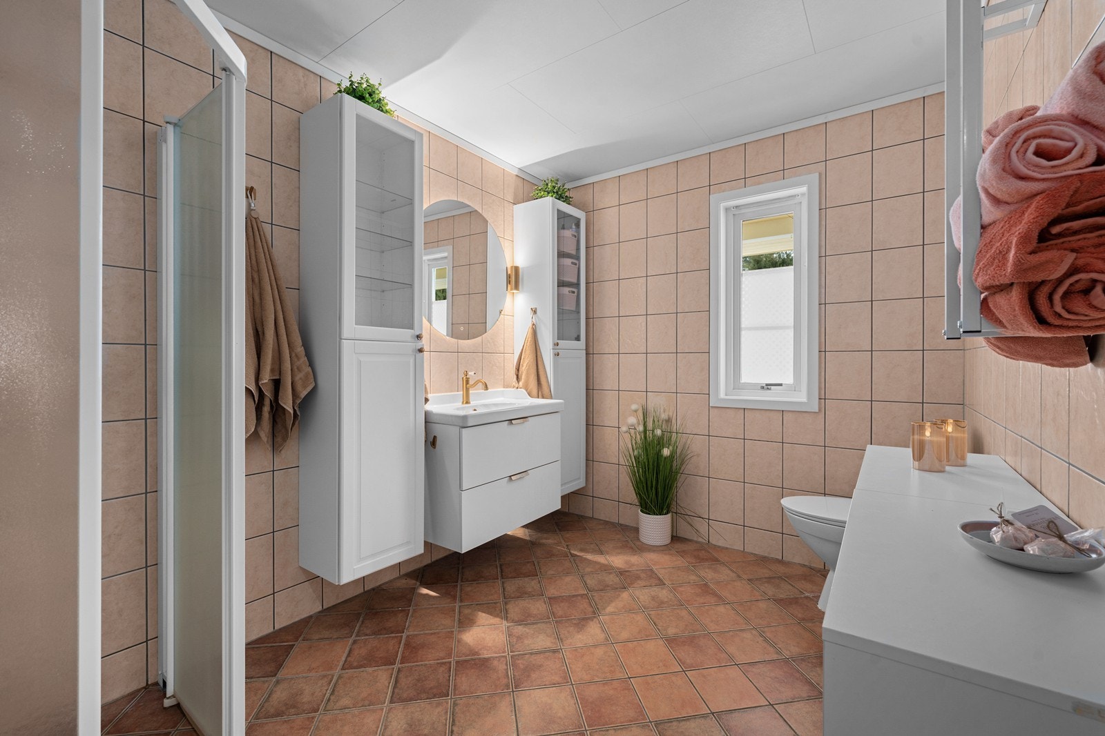 Pent baderom med dusjløsning, toalett, og servant på skuffeseksjon. Galleribilde