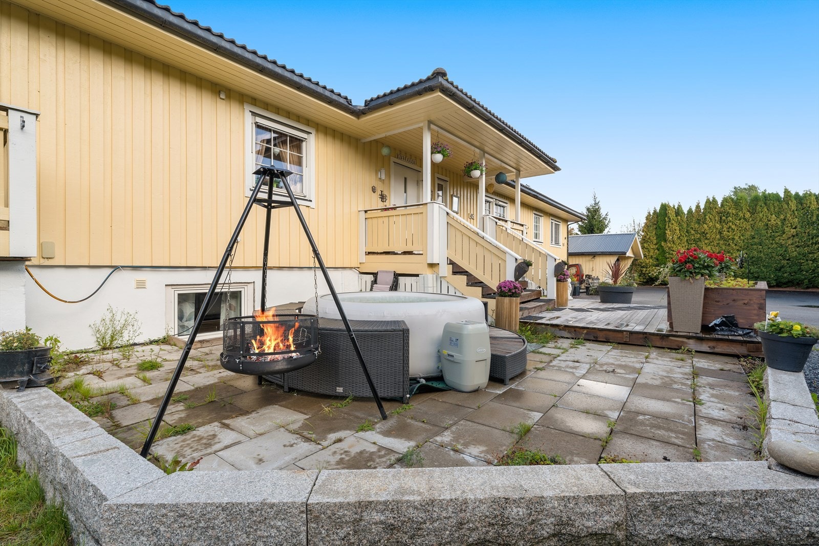 Utenfor er det opparbeidet med stenlagte områder, terrasser og grønt. Galleribilde