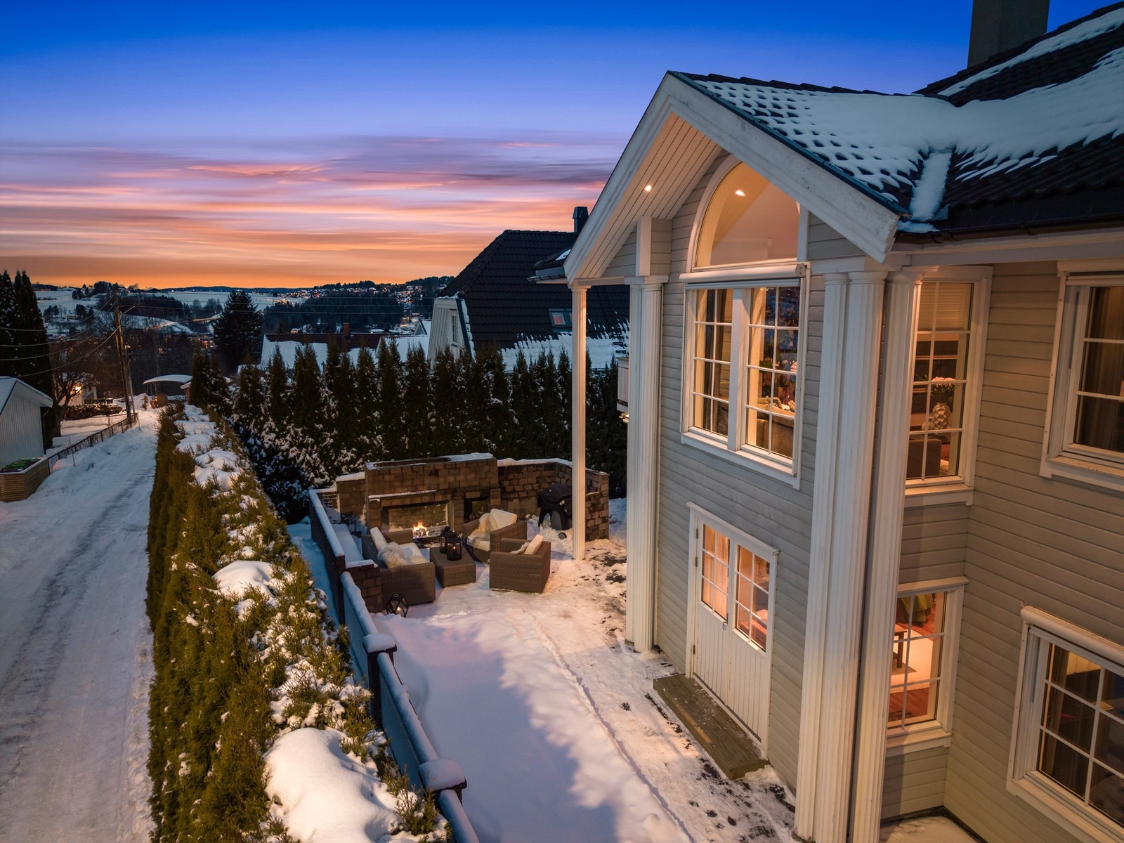 Tomten er pent opparbeidet med belegningsstein, gressplen og hekk som skjermer for innsyn. Galleribilde