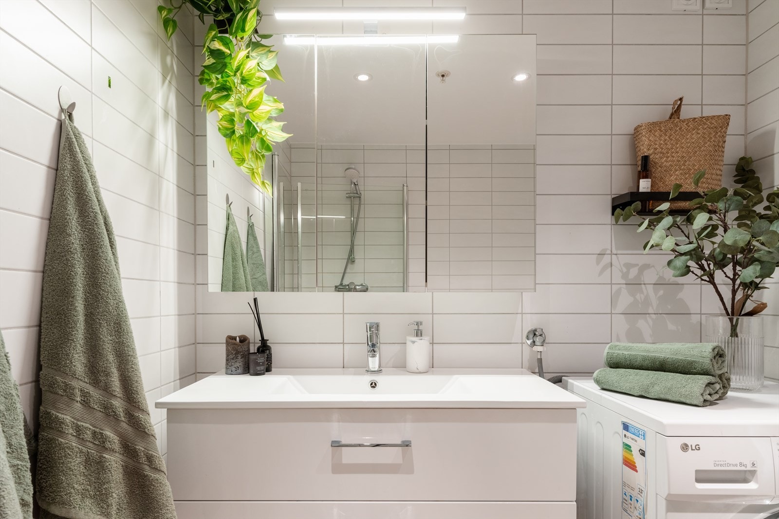 Baderomsinnredningen består av servantskap med skuffeseksjon, vegghengt skap, speil, vegghengt toalett og dusjhjørne med glassvegg Galleribilde