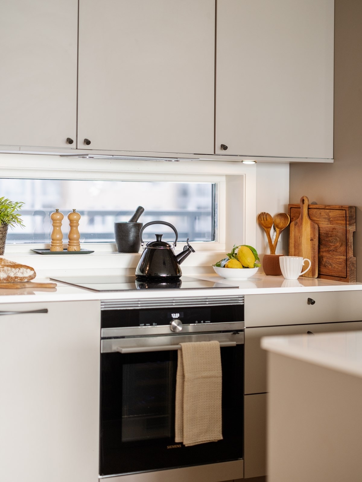 Kjøkkenet er velutstyrt med integrerte hvitevarer som platetopp, stekeovn, oppvaskmaskin og kombinert kjøle- og fryseskap Galleribilde