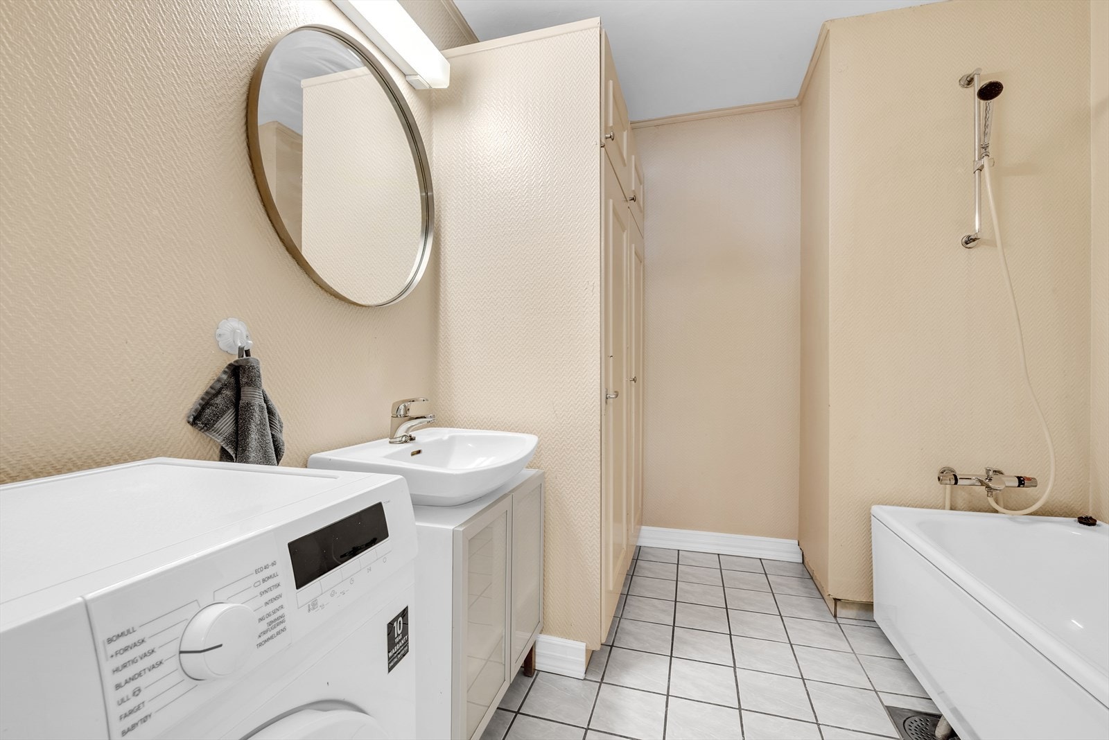 Badet er innredet med badekar, servant med underskap og har opplegg for vaskemaskin. Galleribilde