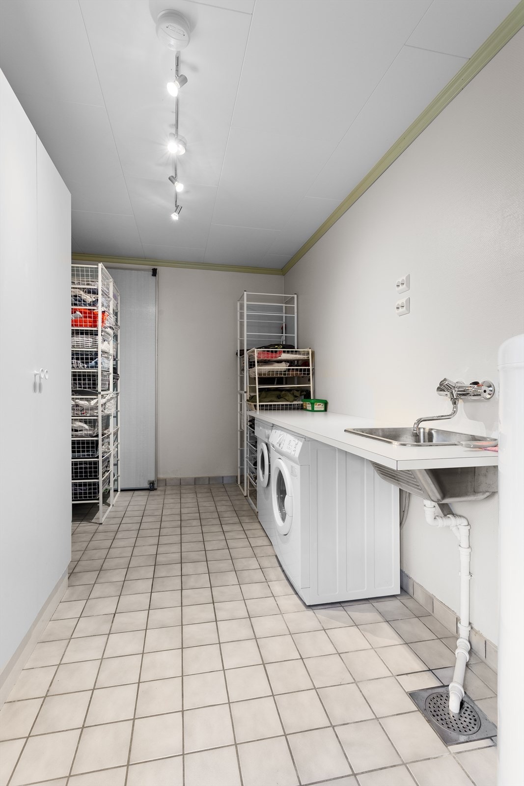 Deler av vaskerommet er opprinnelig ikke utgravd jf. byggetegninger og er ikke godkjent til varig opphold. Innredet med benkeplate over opplegg for vaskemaskin/tørketrommel av laminat med nedfelt oppvaskkum. Galleribilde