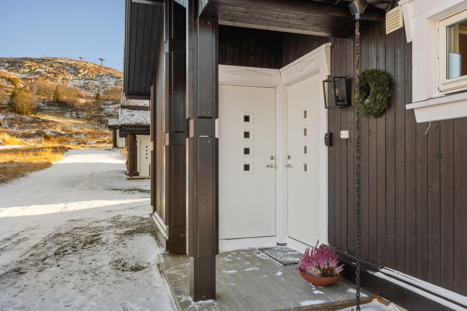 Hytta har et overbygd inngangsparti som gir ly for vær og vind, og gjør det enkelt å komme hjem med skiutstyr eller handleposer. Fra inngangspartiet er det også enkel tilgang til en praktisk bod - perfekt for oppbevaring av ski, ved, sportsutstyr. Galleribilde