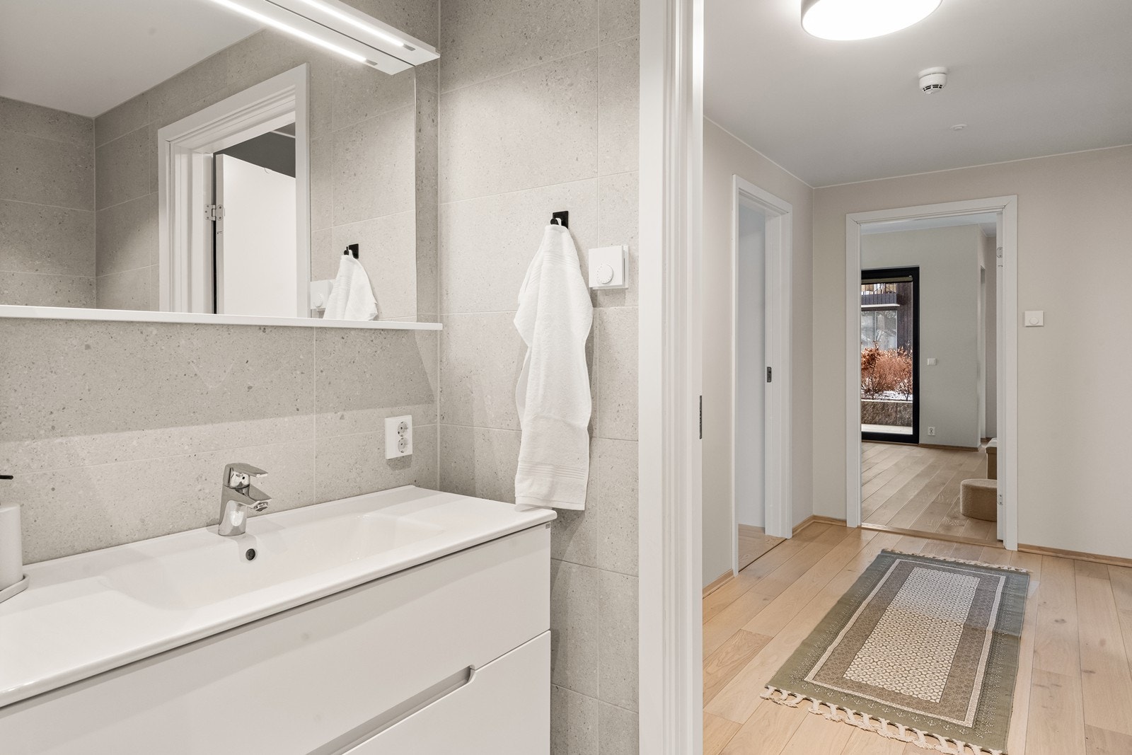 Baderomsinnredning med servant og speil med integrert belysning. Galleribilde