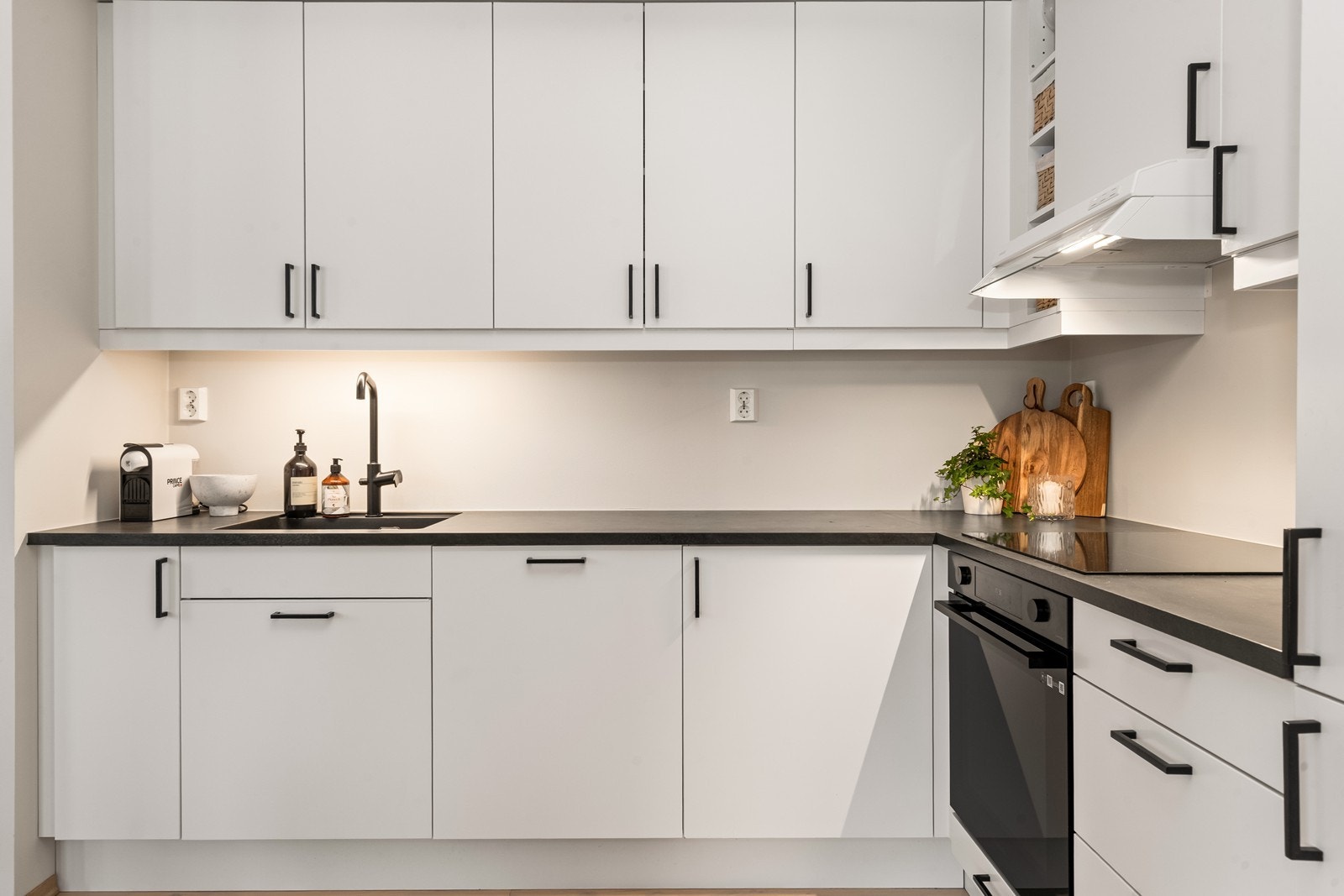 Kjøkkeninnredningen har slette fronter og sorte håndtak som gir et moderne uttrykk. Galleribilde