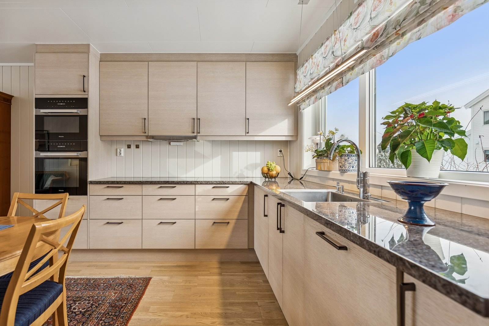 Innredningen fra Sigdal heter Amfi Lin 2.0 i lysbeiset eikefiner. Granittplaten heter Antique Labrador og er 30mm tykk. Det er planlimt Infra Frame vask. Her er det mye fin skap og skuffeplass. Galleribilde