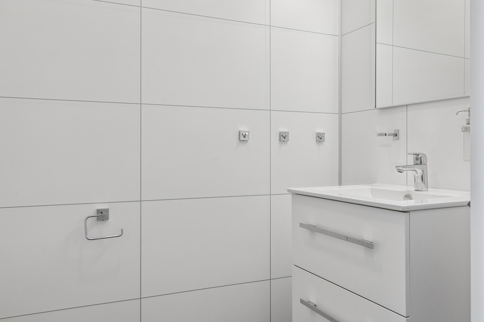 Toalettet/wc - rommet er oppgradert med plater på vegg. Vegghengt klosett, innredning med skuffer, servant og speil og fliser på gulv. Galleribilde