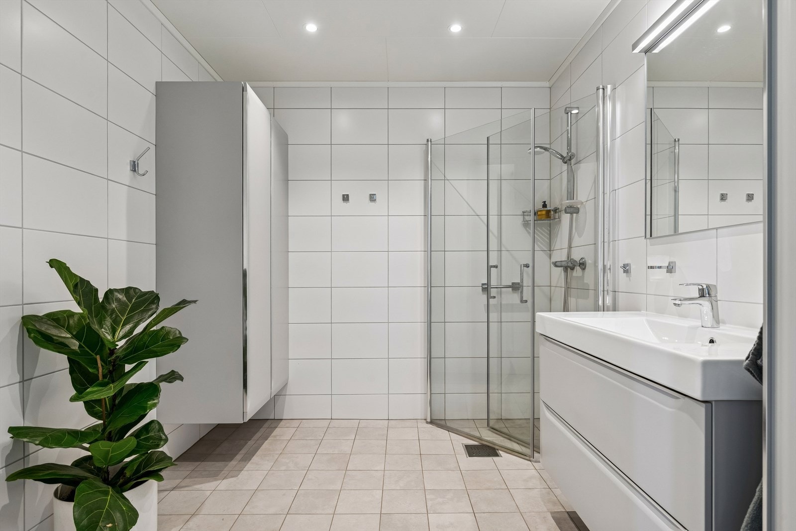 Badet er flislagt og har oppgradert innredning med praktiske høyskap på vegg. Galleribilde