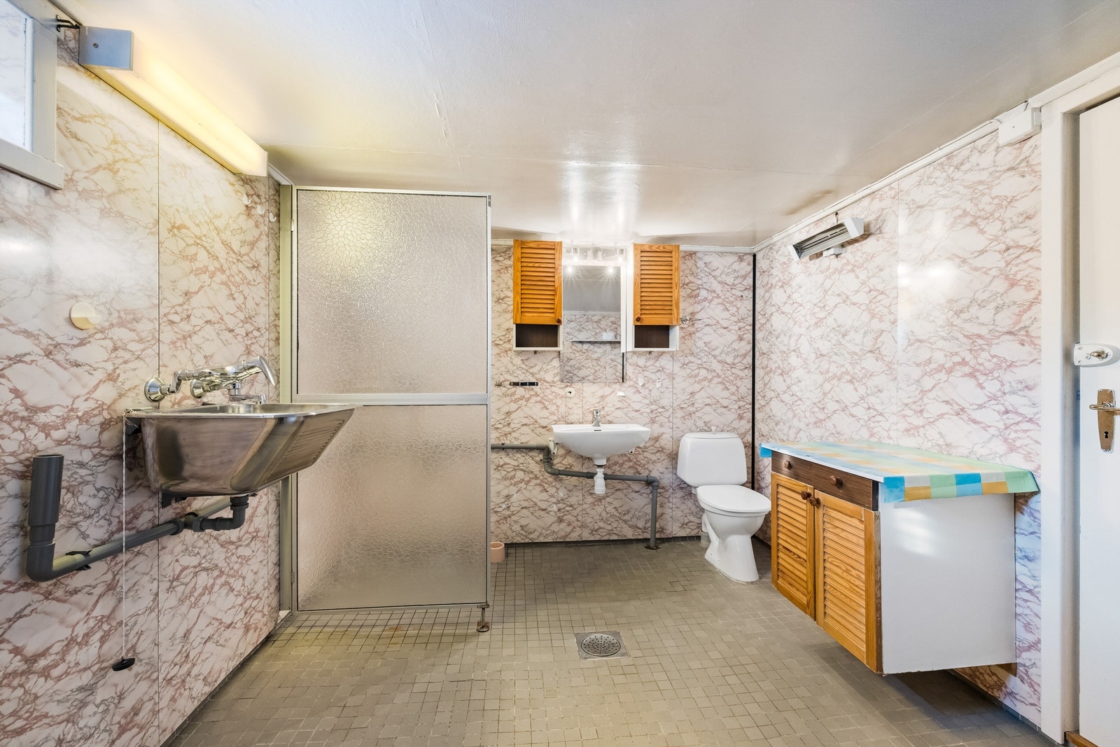 Kombinert bad og vaskerom i kjelleren med flislagt gulv og opplegg for vaskemaskin. Galleribilde