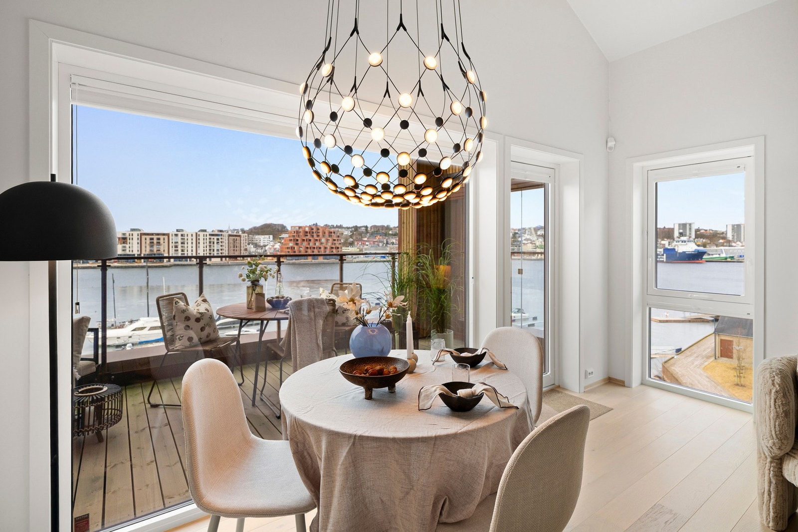 Stue og kjøkken danner et lyst og luftig allrom med store vindusflater som slipper inn rikelig med dagslys og gir flott utsikt Galleribilde