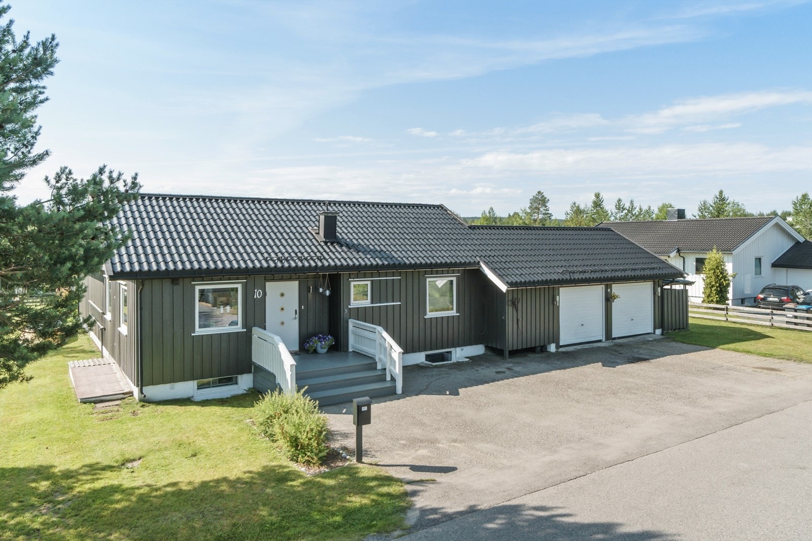 Enebolig med mørk trekledning, integrert dobbelgarasje og romslig gårdsplass. Galleribilde