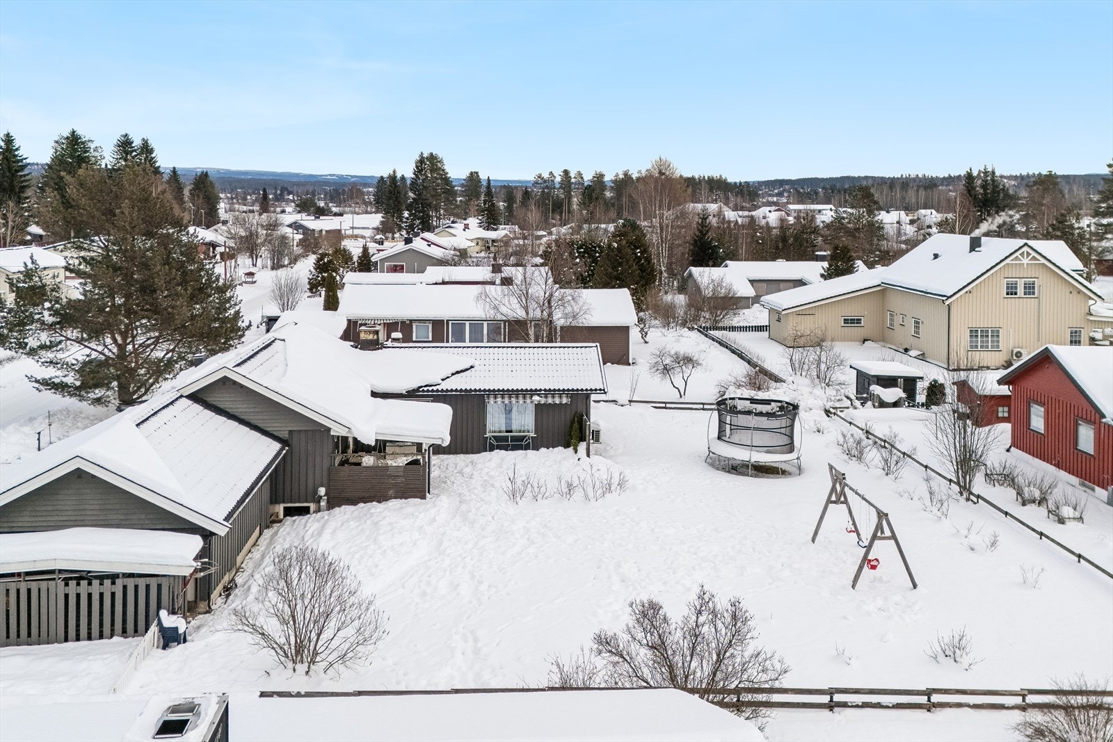 Oversiktsbilde av eiendommen på flat og solrik tomt. Galleribilde