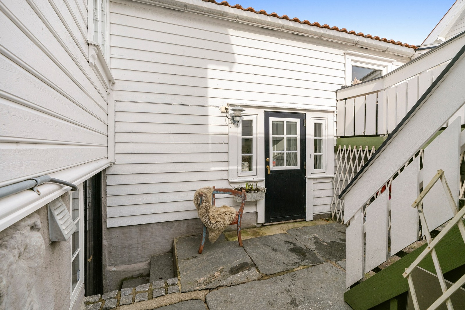 Uteområdet består av skiferdekket gårdsrom og en lun terrasse med trapp mellom nivåene. Galleribilde