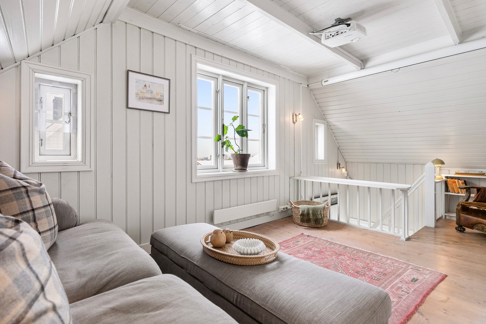 Her finner man en lun og trivelig loftstue med skråtak, stedsbygde bokhyller og fin utsikt. Galleribilde